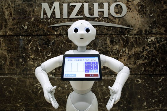 Robot standing next to sign that says