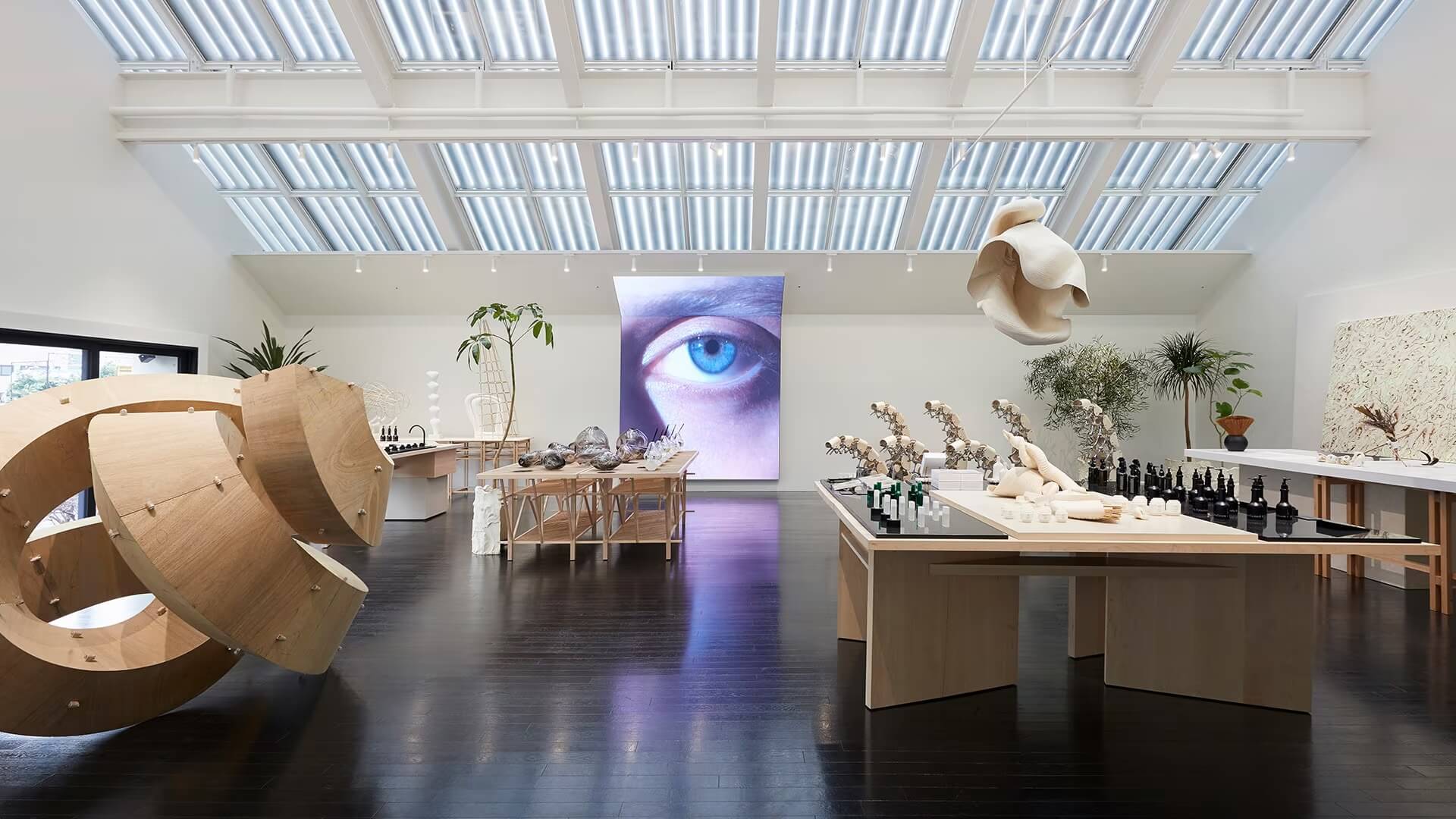 A large, modern art gallery filled with various sculptures and furniture pieces.