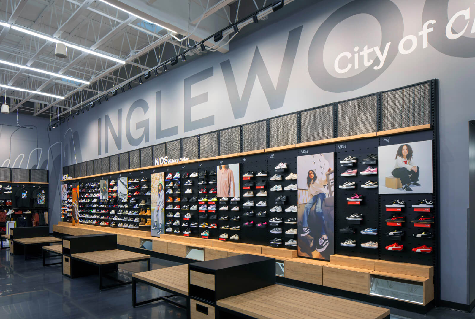 A large store with a variety of shoes on display, featuring an array of sneakers in different colors and styles.