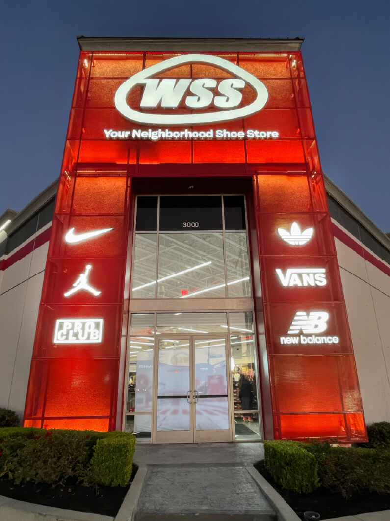 A building at night, illuminated by red lights. A large sign on the building reads