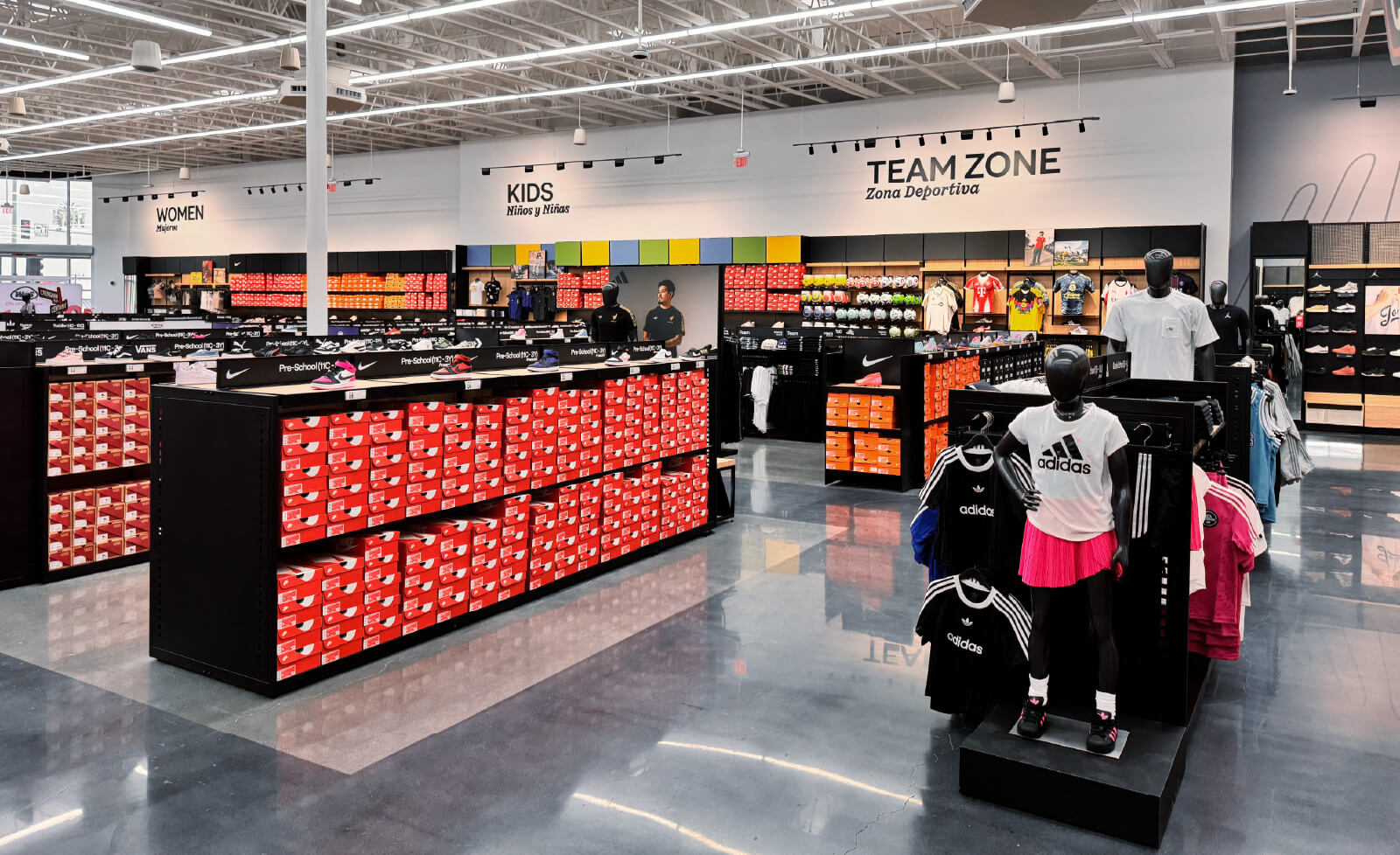 A large store filled with sports shoes, merchandise, and various displays.