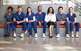 A group of healthcare professionals posing together for a photo in a hospital setting.