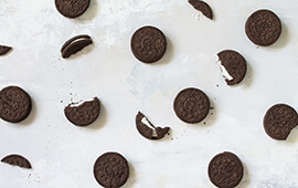A collection of chocolate chip cookies on a white surface.