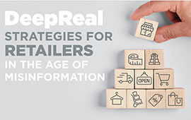 A hand holding a block from a Jenga puzzle, with the blocks forming a pyramid and a sign in front that reads "DeepReal Strategies for Retailers in…