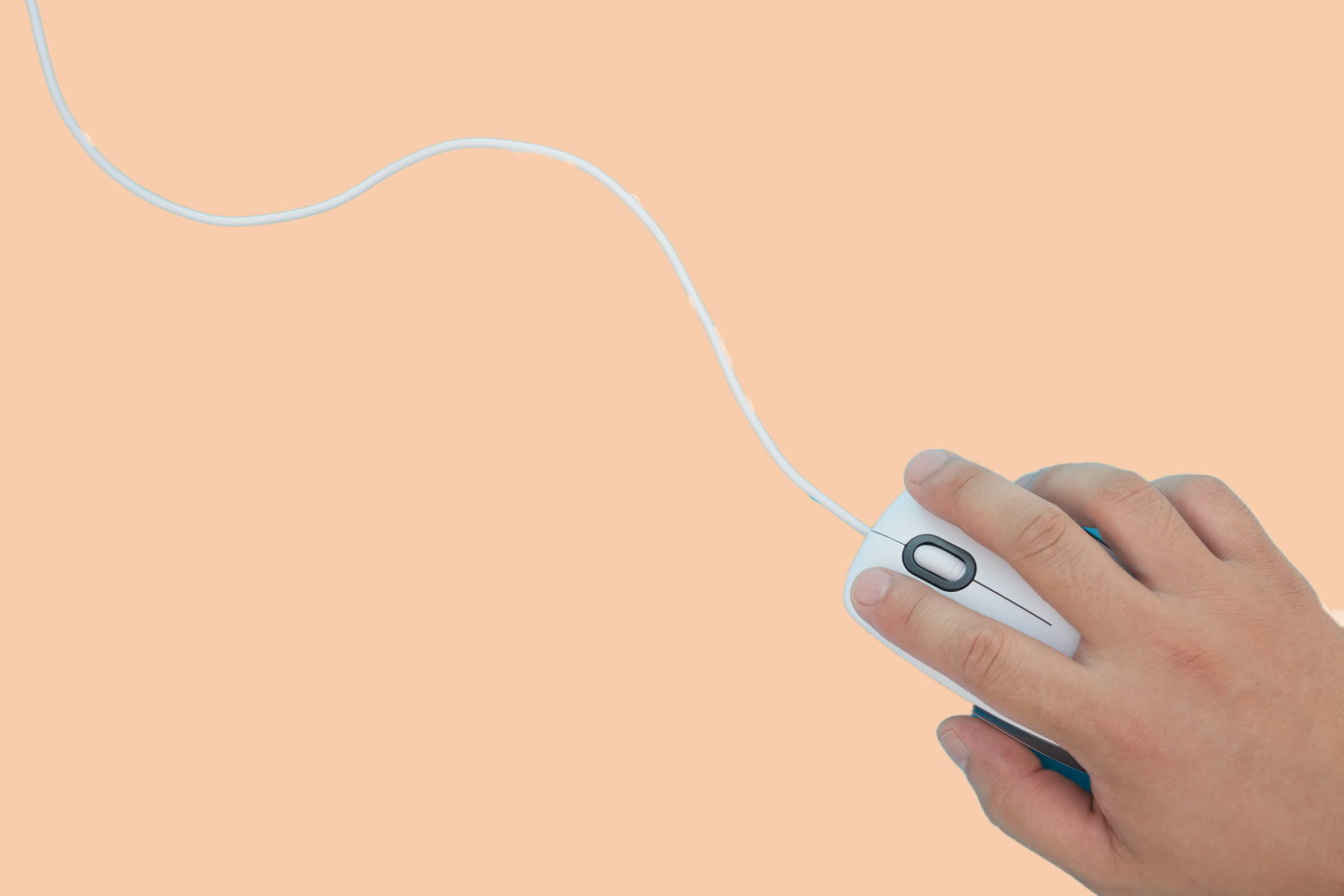 A hand holding a white mouse over a computer keyboard.