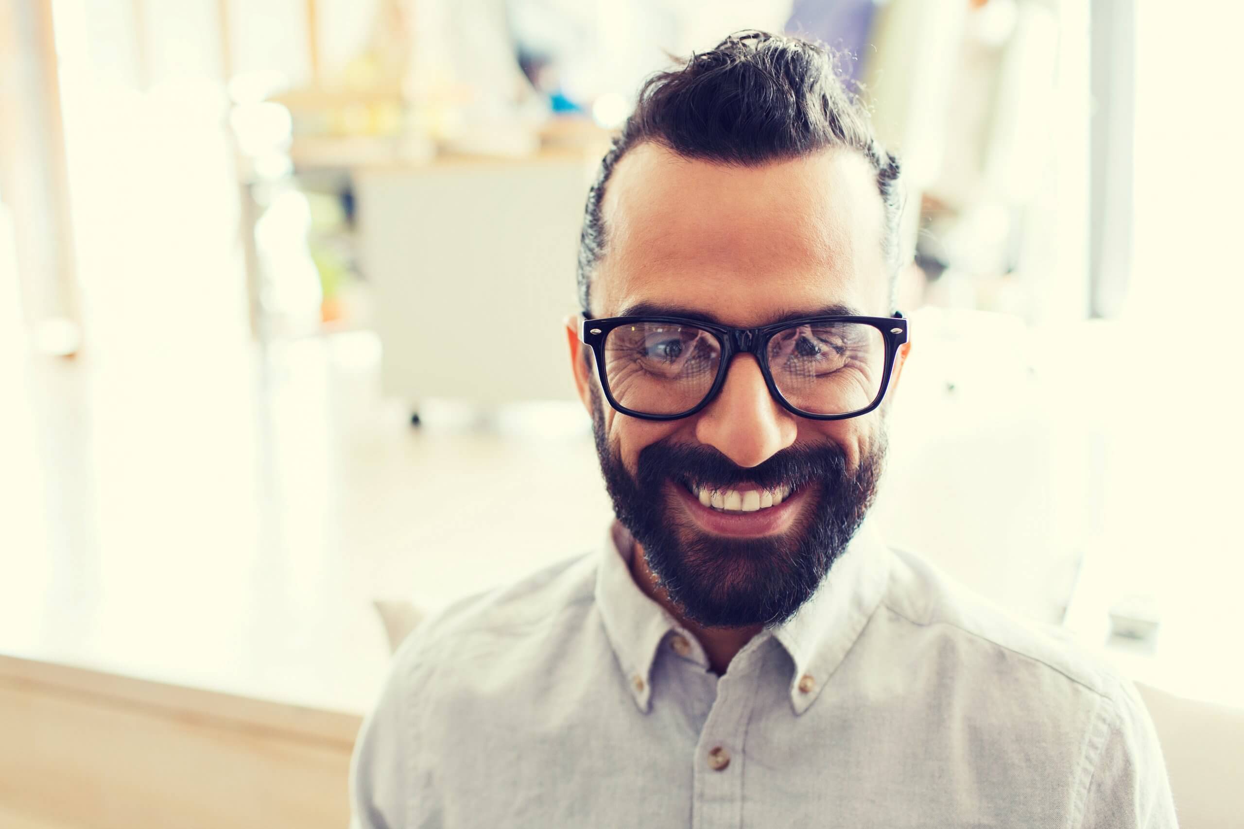 A man wearing glasses, smiling at the camera