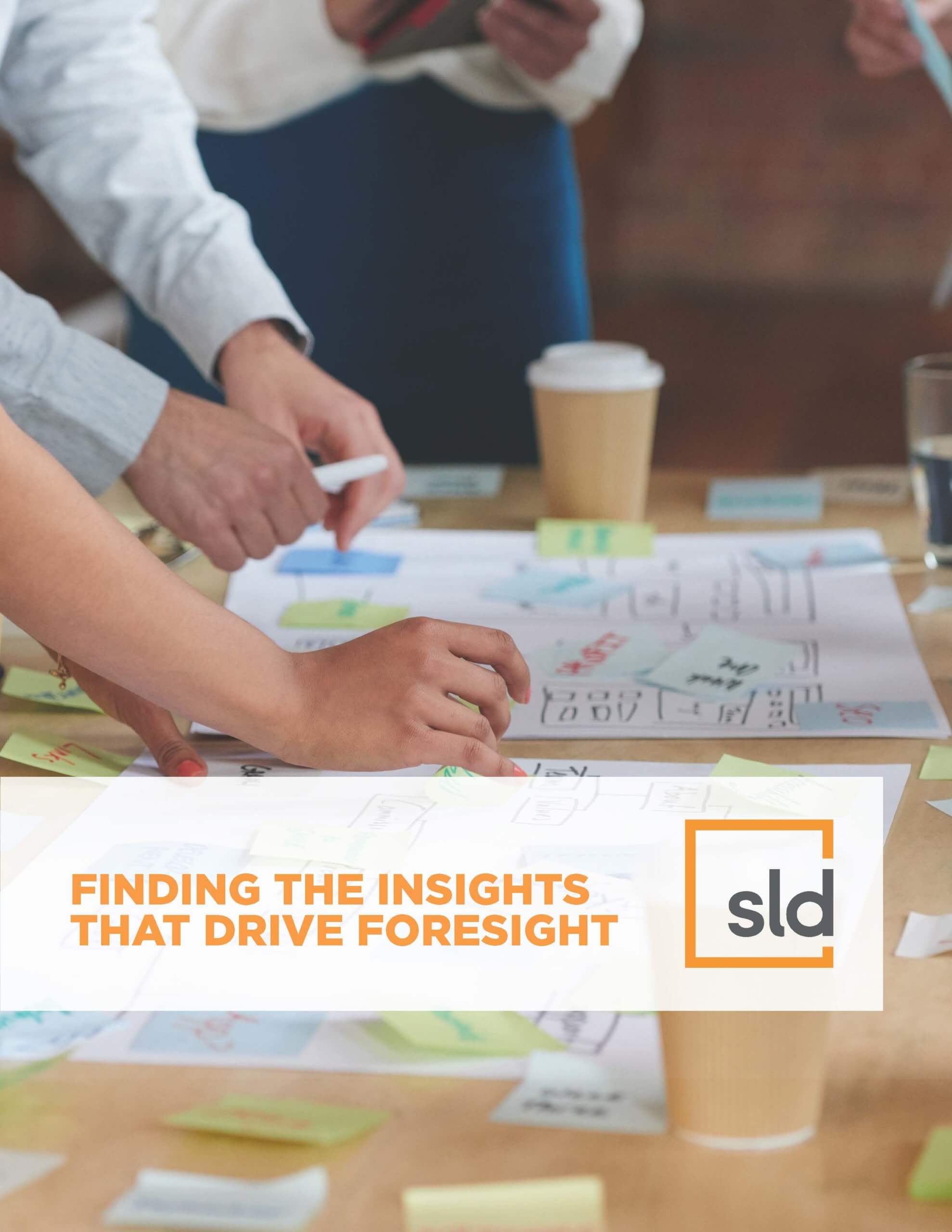 A group of people working on a project, surrounded by paperwork and coffee cups, with the text "FINDING THE INSIGHTS THAT DRIVE FOREIGN VISION"…