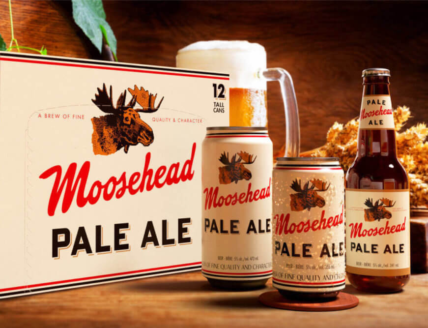 A display of Moosehead Ale beer cans and bottles, featuring a can of pale ale and two bottles of moosehead ale, set against a wooden background.