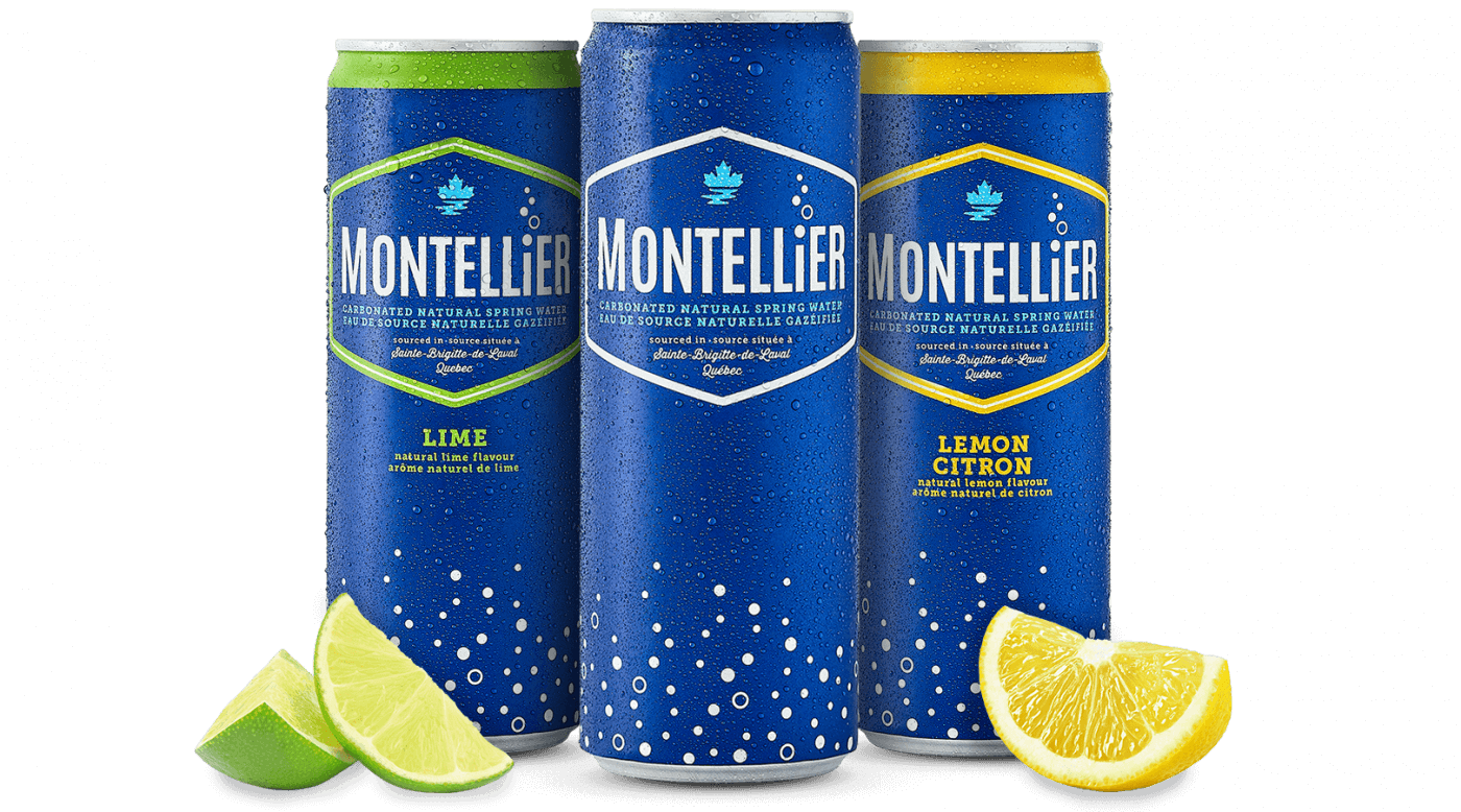 Three cans of Montellier lemonade, two limes, and a can of grapefruit soda on a table.