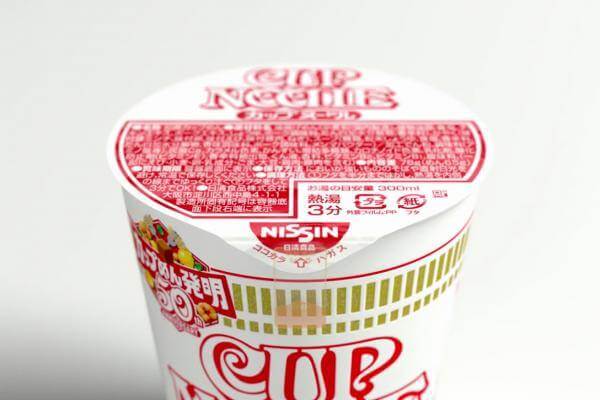 A cup noodle package on a white surface.