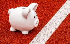 A small toy piggy bank on a red track.