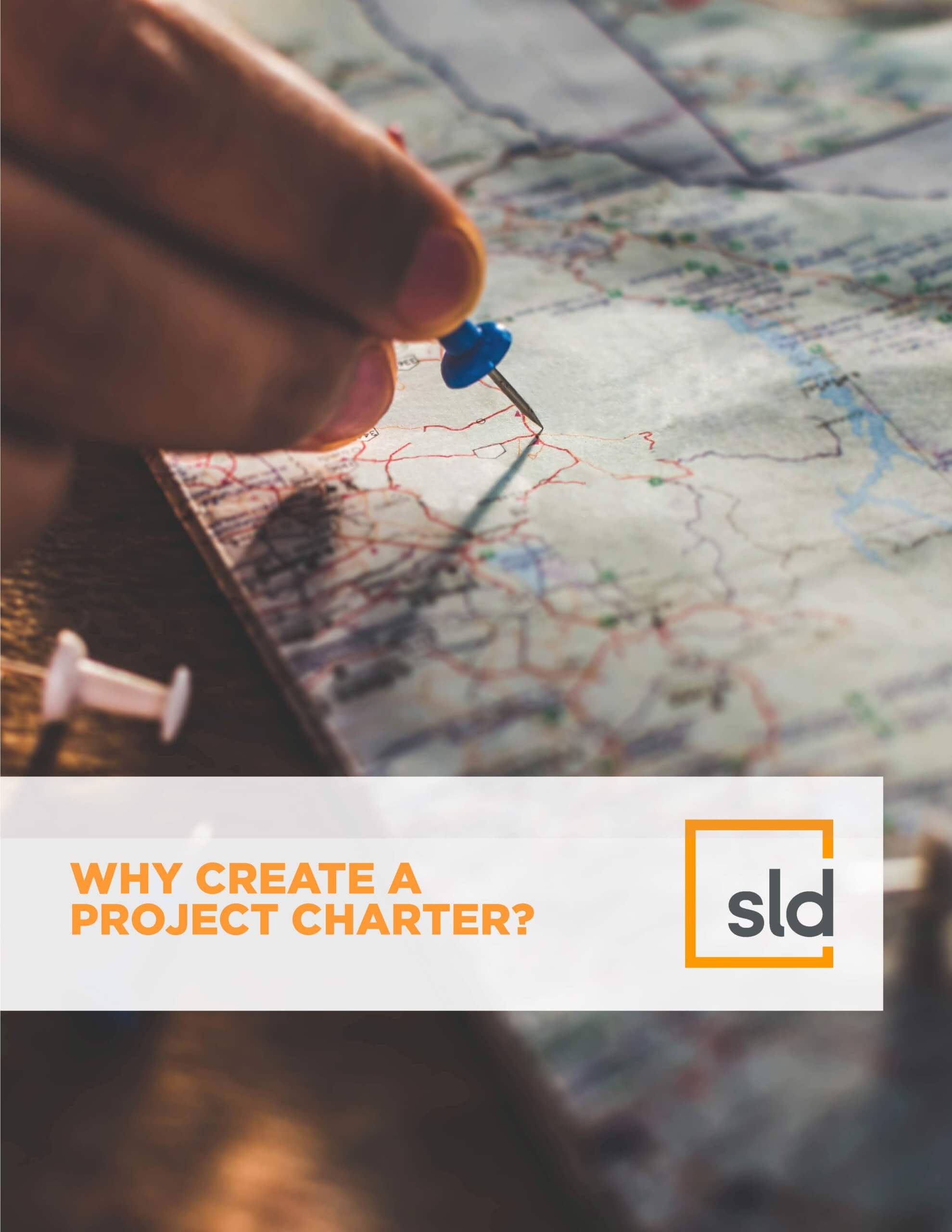 A person's hand holding a compass over a map, with the text "Why create a project charter?" in the foreground.