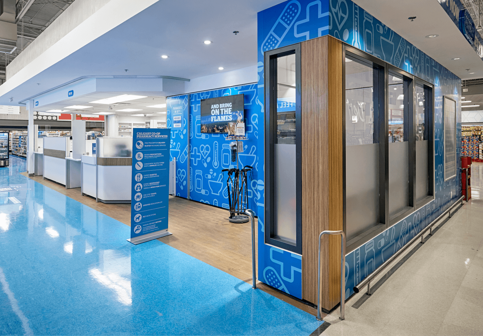 An interior view of a store, featuring a bright blue floor and walls, a large window displaying various items, and a small counter area with a…