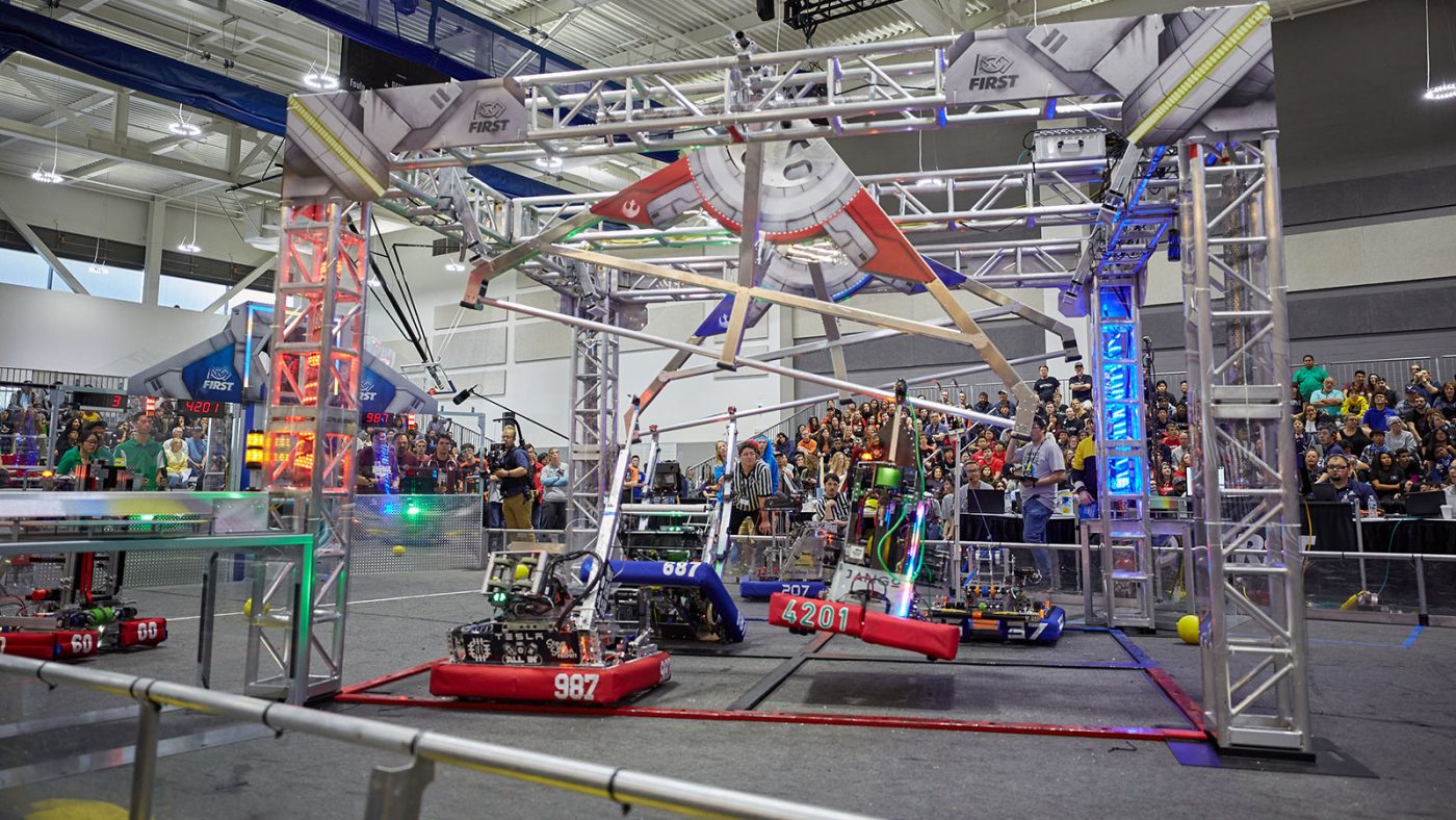 A large, colorful display of remote-controlled cars in a convention hall.