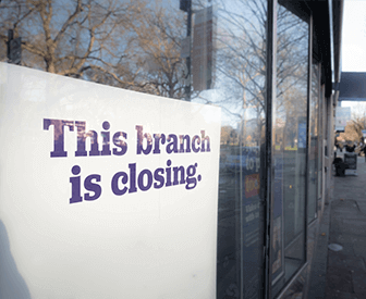 An image of a sign on the window of a closed storefront. The sign reads "This branch is closing.