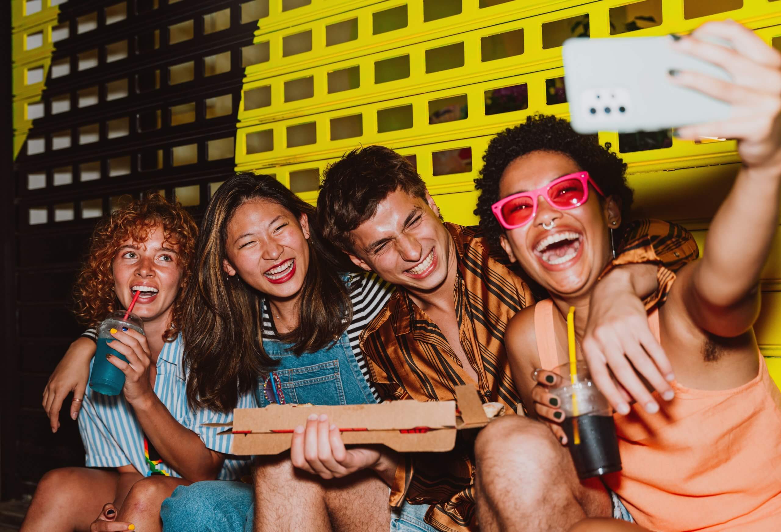 A group of four people posing for a selfie, smiling and enjoying themselves.