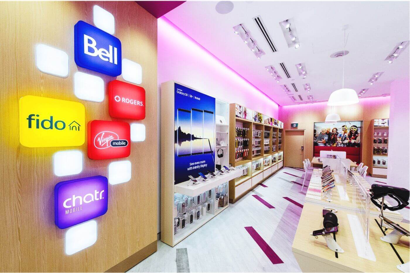 A store interior with colorful neon signs, a pink ceiling, and various products on shelves.